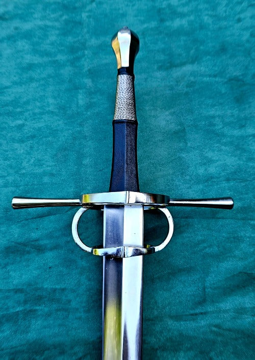 A European Renaissance Hand and a Half Sword with a cross-guard, featuring a carbon steel blade, wooden grip, and faceted steel pommel.