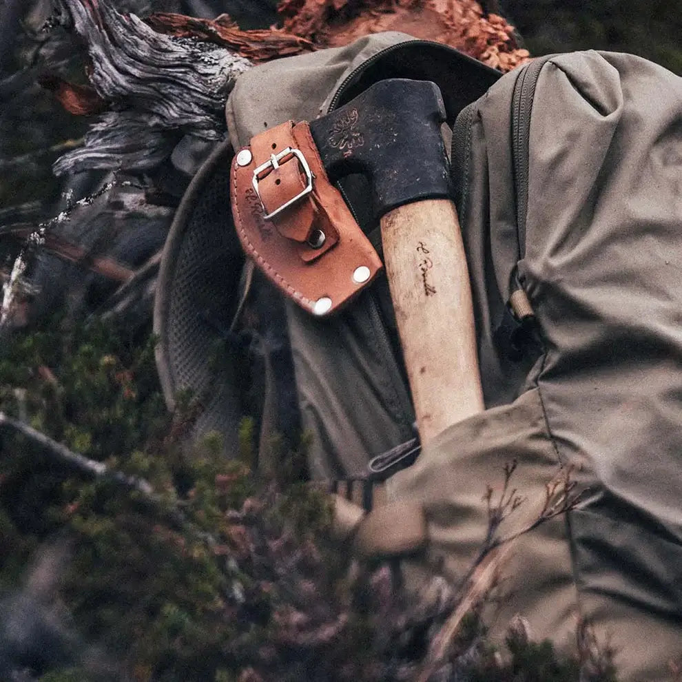 Roselli R850 The Axe, Long Handle resting on a backpack in a forest setting.