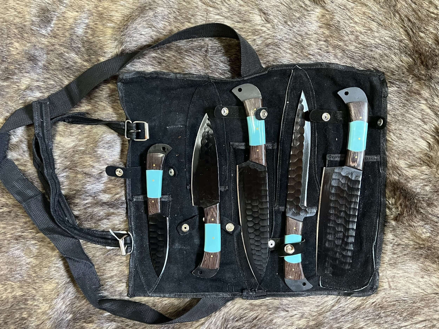 Set of knives in a black sheath with faux turquoise accents on a fur background