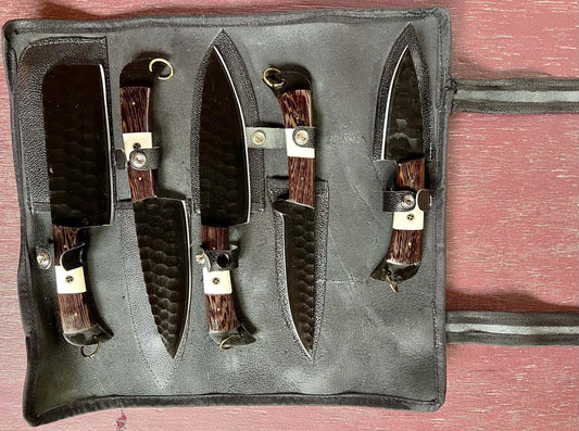 A set of 5 kitchen knives with wooden and bone handles, displayed in a black suede leather roll.