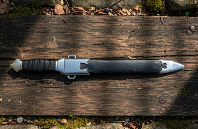 Eastern Dirk on wooden surface, featuring a leather-wrapped grip and intricate blade details.