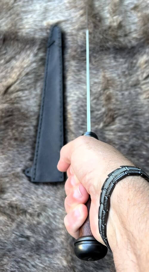 Irish Scian in hand with sheath on fur background