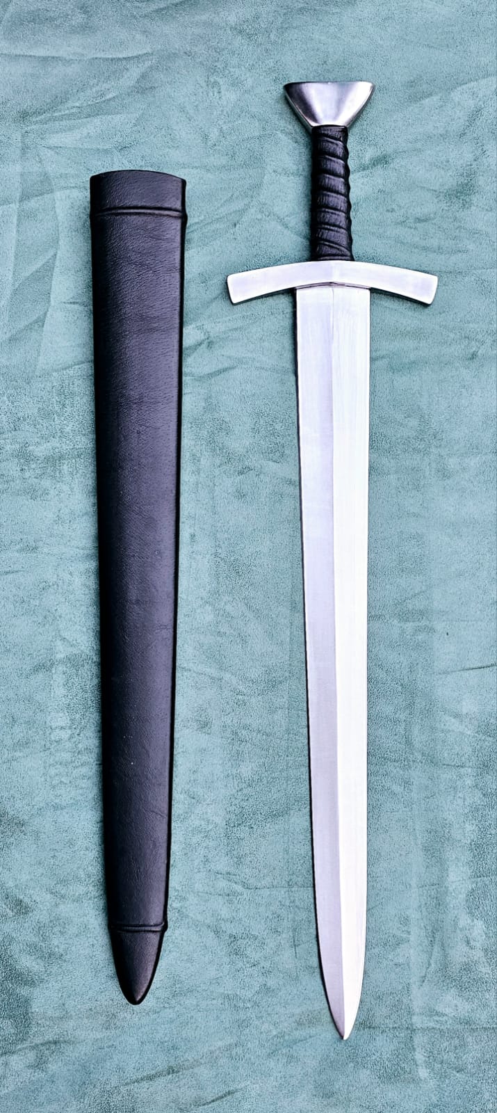 A replica of a Bowman's Short Sword from the Middle Ages with a wood lined leather covered scabbard. The blade is made from carbon steel and has a sharp edge.