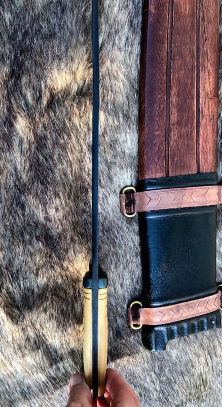 Iberian falcata sword with a wooden handle and ornate sheath, showcasing ancient craftsmanship and design details.