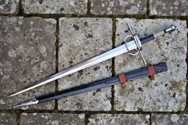 Two gothic bastard swords displayed on a stone surface, showcasing their design in The Gothic Bastard Sword Guide.