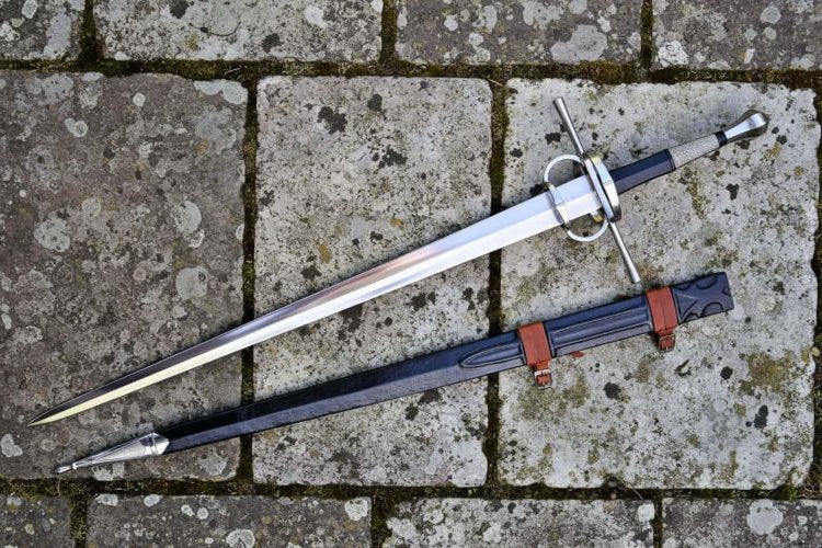 Two gothic bastard swords displayed on a stone surface, showcasing their design in The Gothic Bastard Sword Guide.