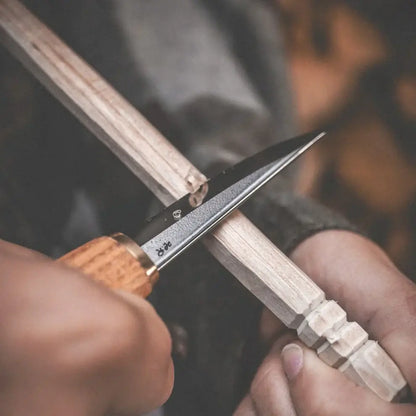 Roselli R113D The Carving Knife (Short Blade)- Red Elm in use for detailed wood carving on a wooden piece.