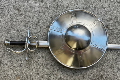 14 Buckler and Complex Hilt Sidesword Combo displayed on a stone surface, showcasing the hammered steel craftsmanship.