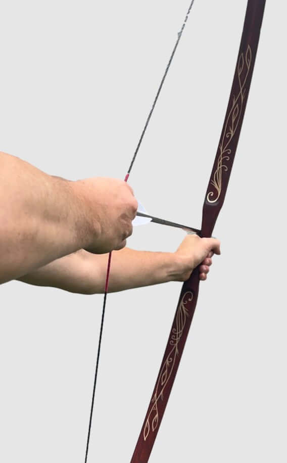 Person demonstrating the Handmade Hickory Elven Bow with a steady grip, showcasing intricate designs and archery technique.