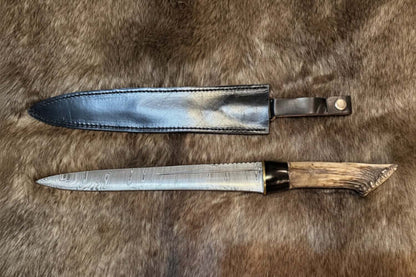 Scottish dirk with crown stag handle and Damascus blade displayed with sheath