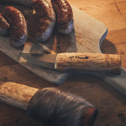 Roselli R121 The Grandfather Knife with Special Sheath beside sausages on a cutting board.