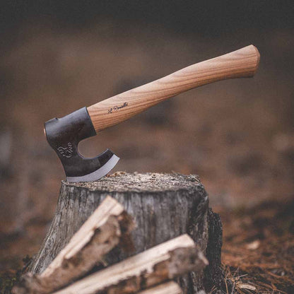 Roselli R860D The Axe, Short Handle Red Elm on a stump with firewood in the foreground, showcasing its craftsmanship.