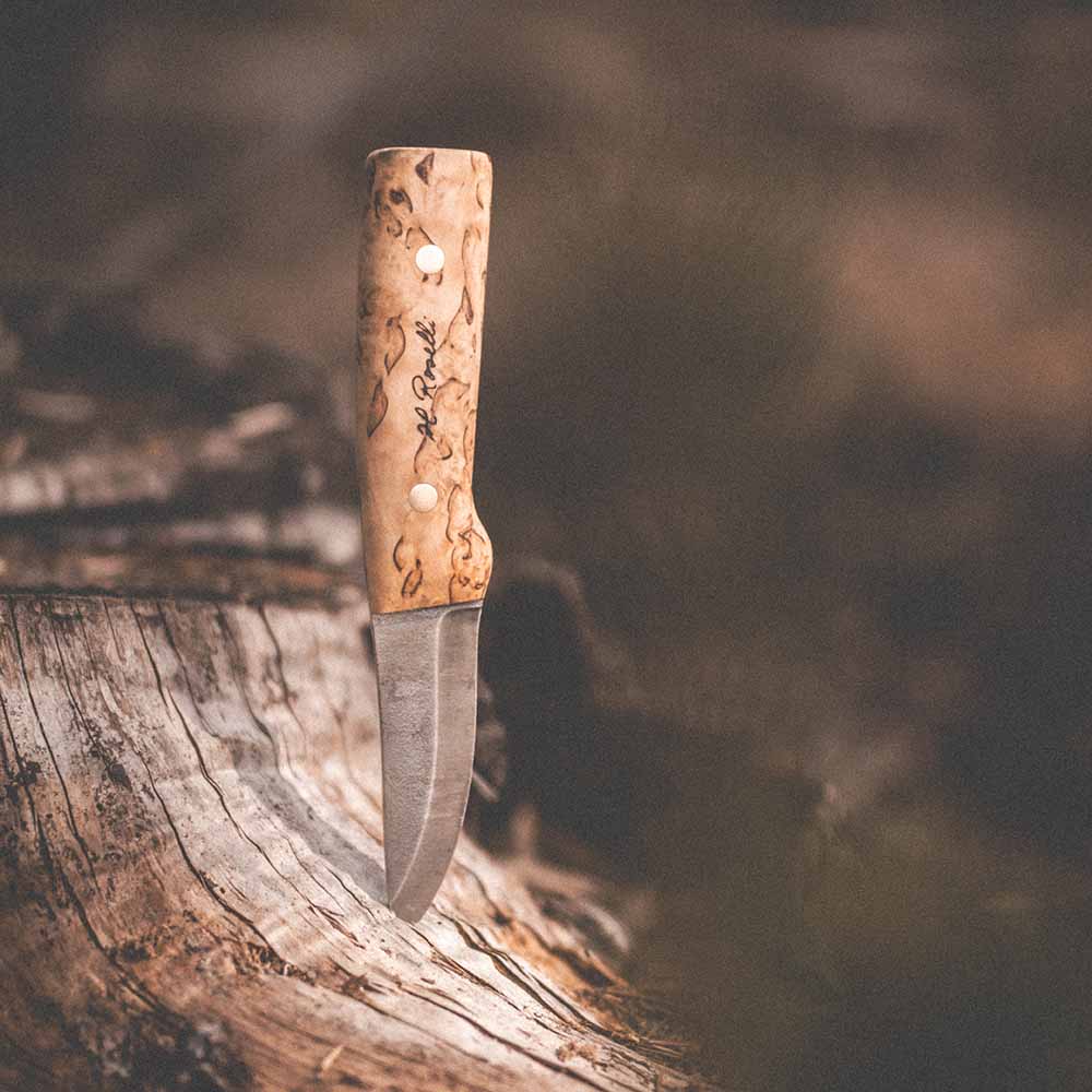 Roselli Hunter FULL TANG R100F knife with a curly birch handle resting on a wooden log.