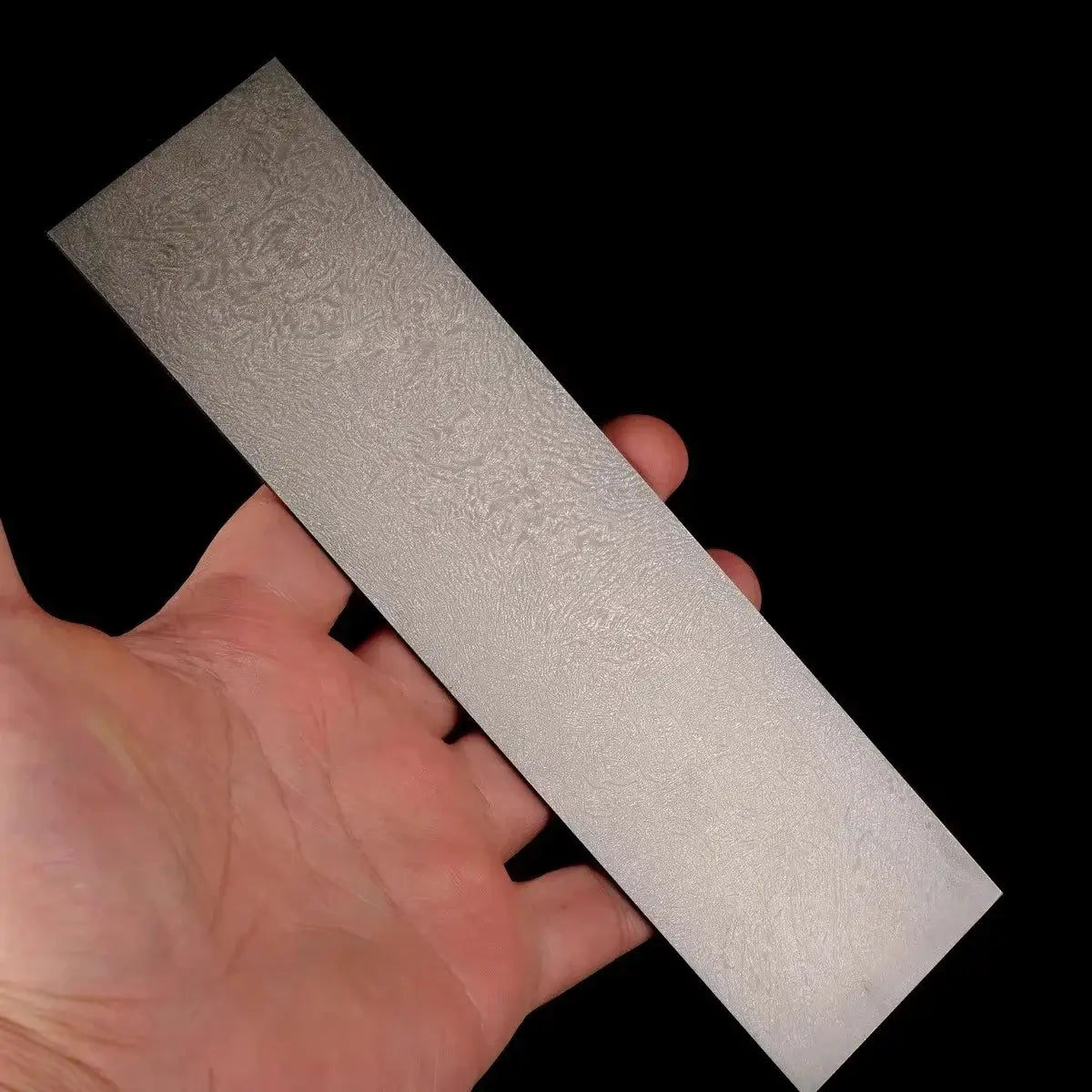 Wootz Steel Knife Making Damascus Blanks shown in hand, displaying unique pattern and texture.