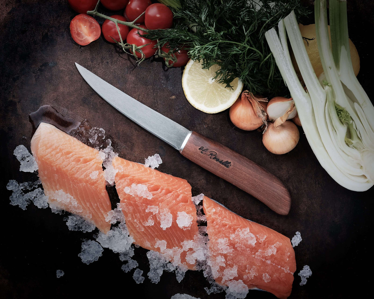 Roselli RW256 The Small Fillet Knife placed on ice with salmon fillets, cherry tomatoes, and fresh herbs.